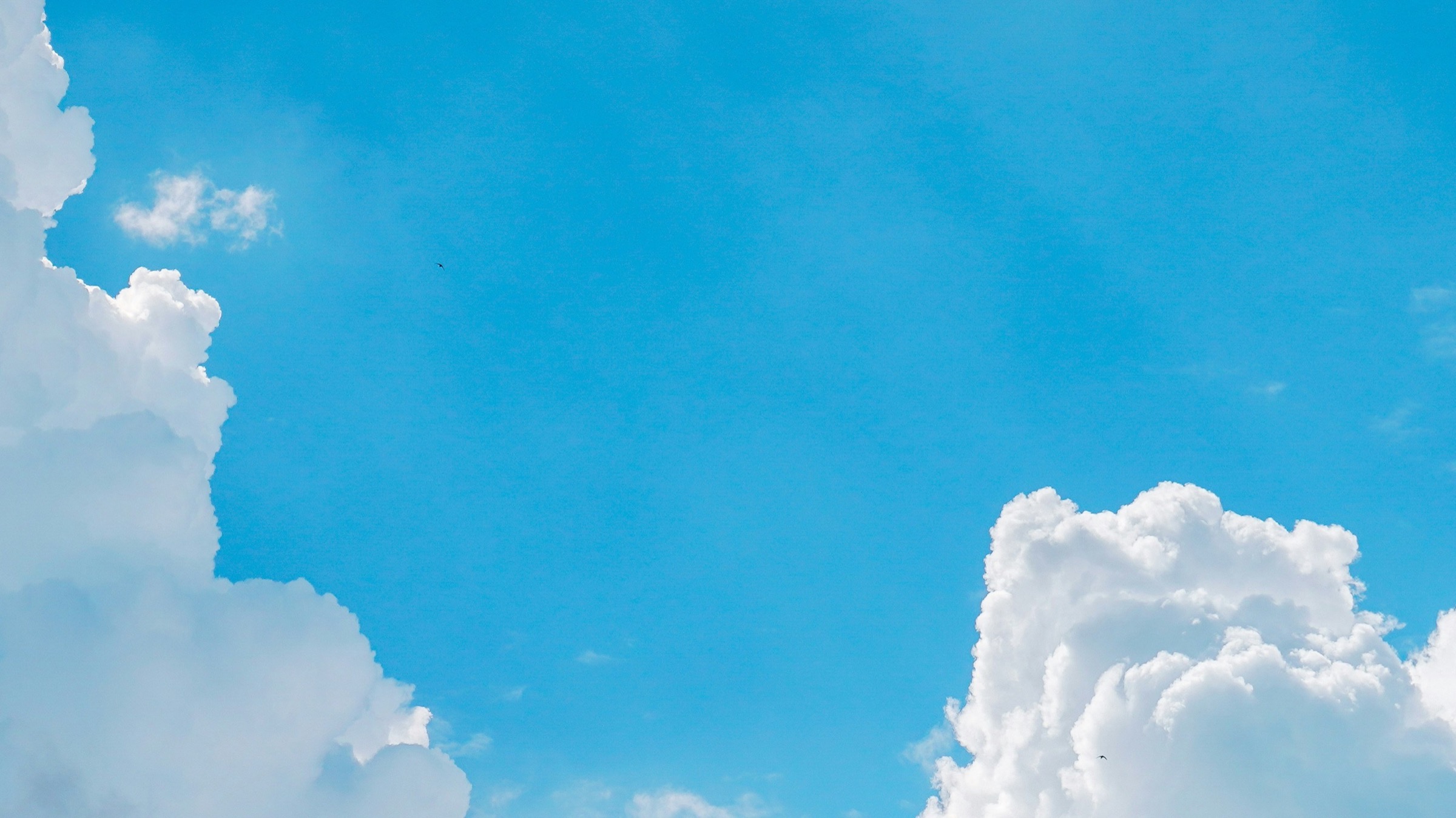 A bright blue sky with white clouds along the bottom